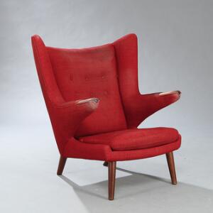 Hans J. Wegner Bamsestol. Lænestol med negle samt ben af teak. Sider, sæde, løs nakkehynde samt dybthæftet ryg betrukket med rød uld.