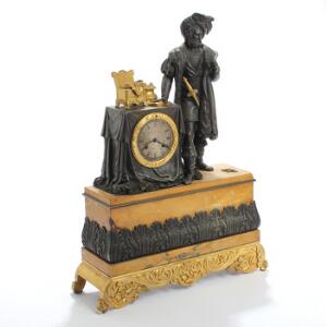 Fransk kaminur af forgyldt og sortpatineret bronze, base med gul marmor, ved siden af urhus figur i form af fornem herre. Ca. 1840. H. 59.