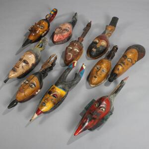 En samling afrikanske masker af udskåret og bemalet træ. 20. årh.s anden halvdel. H. 57-70. 10