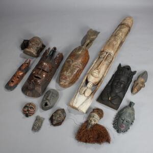 En samling større og mindre afrikanske masker af udskåret og delvis bemalet træ. 20. årh.s anden halvdel. H. 19,5-186. 13