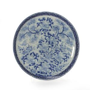 Stort japansk fad af porcelæn, dekoreret i underglasur blå med blomstrende kirsebær træ, pæoner og fugle. 20. århs begyndelse. Diam. 55 cm.