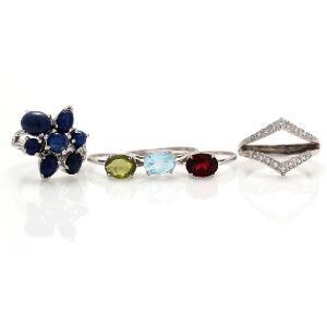 Fire ringe af sterlingsølv, prydet med henholdsvis facetsleben granat, peridot og topas, og cabochonslebne lapis lazuli. Ring prydet med hvide sten medfølger.