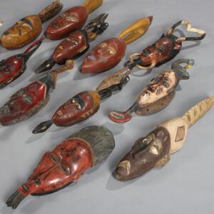 En samling afrikanske masker af udskåret og bemalet træ. 20. årh.s anden halvdel. H. 60-70. 12