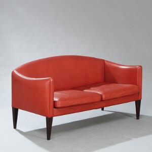 Illum Wikkelsø Fritstående to-personers sofa med tilspidsende ben af palisander. Betrukket med rødt farvet skind. Model V. 12.