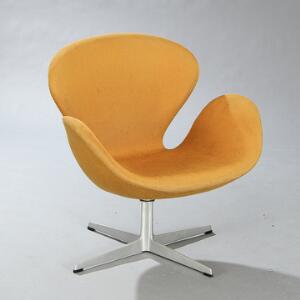 Arne Jacobsen Svanen. Hvilestol opsat på drejestel samt firpasfod af aluminium. Sæde og ryg betrukket med gul uld. Udført hos Fritz Hansen.