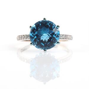 Topaz- og diamantring af 14 kt. hvidguld prydet med facetslebet topaz flankeret af brillantslebne diamanter. Str. 55.