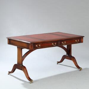 Engelsk fritstående skrivebord af mahogni, plade indlagt med rødt læder, front med to skuffer. Regency form, 20. årh. H. 75. L. 138. B. 80.