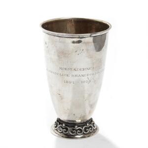 Pokal af sølv, glat korpus opsat på rundt fodstykke prydet med ornamentik. Mester Fritz Heimbürger, 1934. Vægt ca. 304 gr. H. 18,3.