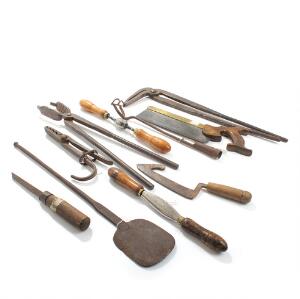 En samling diverse håndværktøj, bl.a. sav, tænger og spade. 19.-20. årh. L. 25-52. 10
