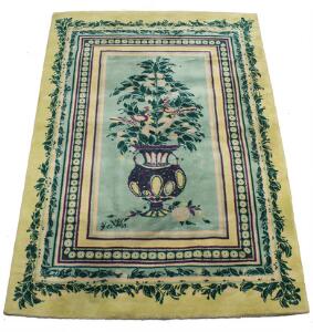 Bjørn Wiinblad Rektangulært tæppe knyttet af uld, dekoreret med blomster i vase og ornamenter i grønne nuancer. Sign. BW 69. 292 x 200.