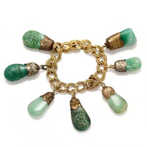 Armbånd af 18 kt. guld prydet med forgyldte jadevedhæng. L. 17 cm. To ekstra vedhæng af sten medfølger. Vægt ialt 90 gr.