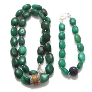 Smaragdsmykkesæt bestående af halskæde og armbånd prydet med perler af cabochonslebne smaragder samt facetslebet safir. L. ca. 47,5 og 19 cm. 2