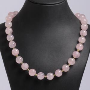 Rosenkvarts- og peridotsmykkesæt bestående af halskæde og ørestikker prydet med perler af cabochonslebne rosenkvarts og peridoter. Perlediam. ca. 0,3-1,3 cm.
