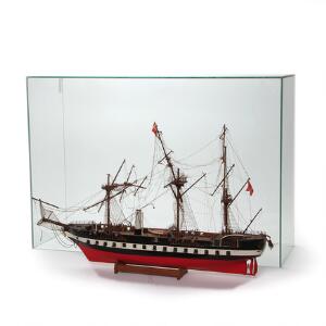 Modelskib af bemalt træ i form af Fregatten Jylland med rigning og kanoner samt montre af glas. L. 75 cm.