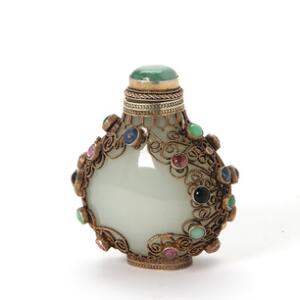 Kinesisk snuff bottle af jade dekoreret med sølvmonteringer og talrige flusser. 20. årh.s første halvdel. H. 5 cm.