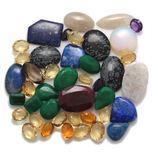 Større samling af uindfattede facet- og cabochonslebne smykkesten, bestående af bl.a. lapis lazuli, citriner, smaragder, agat, rubin og ametyst.
