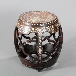 Garden seat af hårdtræ, rigt dekoreret med indlægninger af perlemor, sæde af rosabroget marmor. 20. årh. H. 51,5. Diam. 42.