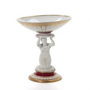 Konfektskål af porcelæn, dekoreret i kirsebærrødt og guld, stamme i form af kvinde. Den kongelige Porcelænsfabrik, ca. 1870. H. 29 cm. Diam. 26 cm.