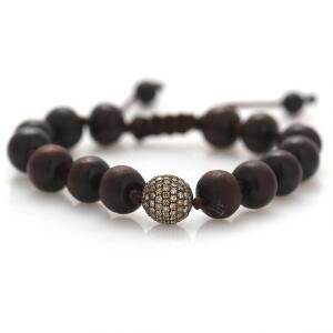Armbånd af knyttet brun lædersnor prydet med perler af træ samt sølvkugle prydet med talrige brillantslebne diamanter. L. ca. 17 cm.