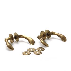Arne Jacobsen To sæt dørgreb af patineret messing med tilhørende to sæt nøgleskilte. Formgivet til SAS Royal Hotel, 1958. L. 11. 2