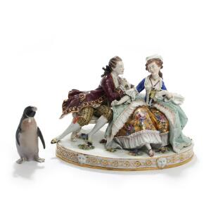 Kurtiserende par og pingvin. To figurer af porcelæn dekoreret i farver og guld. H. 12 og 21,5. 2