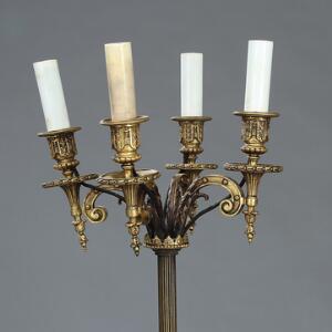 Standerlampe af bronze, med arme til fire lys og fodstykke med tre hvilende sfinkser. Empirestil, 20. årh.s begyndelse. Monteret til el. H. 143.