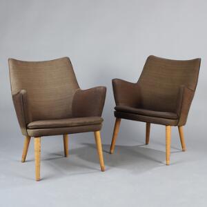 Hans J. Wegner AP 2018. Et par lænestole med ben af egetræ, sæder, ryg og sider med brunt uld. Udført hos AP-Stolen, København. 2
