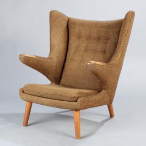 Hans J. Wegner Bamsestol. Øreklapstol med ben og negle af egetræ, betrukket med brunt uld. Udført hos A.P. Stolen.