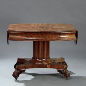 Ovalt senempire bord af mahogny, med konkav sarg hvori skuffe samt firpas fodstykke med akantus blad og messinghul. Ca. 1830. H. 76. L. 98148. D. 85. 85.