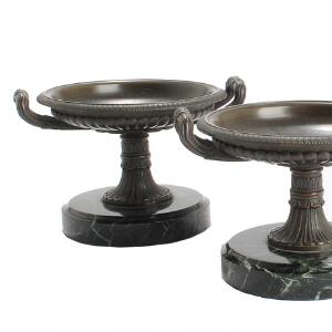 Et par tazze af patineret bronze, støbt med ornamenttik, opsat på runde fodstykker af marmor. 19. årh.s slutning. H. 10. Diam. 13.5. 2