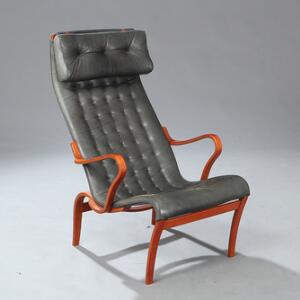 Bruno Mathsson Miranda. Lænestol med stel af bejdset bøg. Sæde, ryg samt nakkehynde betrukket med grå farvet, dybthæftet skind.