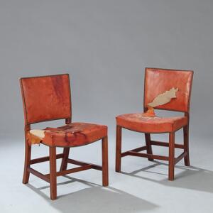 Kaare Klint Den røde stol. Et par sidestole med stel af mahogni. Sæde samt ryg betrukket med sømbeslået rødt skind. 2