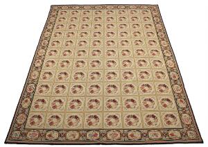 Needlepoint tæppe, all-over design med blomsterkranse og bladværk på okkerfarvet bund. 20. årh. 432 x 320.