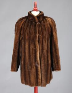Kort frakke af mørkbrun minkpels, syet med kinakrave, pelshægter og indstiklommer. Fire minkskind medfølger. 5