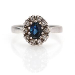 Safir- og diamantring af 14 kt. hvidguld prydet med facetslebet safir omkranset af brillantslebne diamanter. Str. 55.