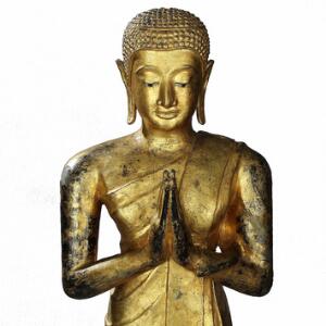 Thailandsk munk af forgyldt bronze stående i namaskara i folderige gevandter. Ca. 1900. H. 122 cm. Med sokkel 143 cm.