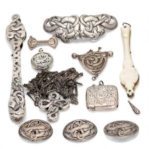 En samling smykker af sølv m.m. bestående af to lorgnetter, lommeur, kors med kæde, spænde uden lås, fire  brocher, to vedhæng og en tændstikholder. 11
