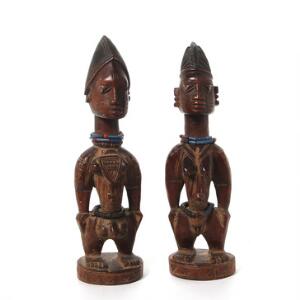 Ere Ibeji. Et par tvillingefigurer mand og kvinde. Træ med sort-brun patina. Yoroba. Nigeria. H. 33 og 32. 2