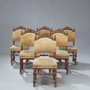 Et sæt på 18 spisestuestole af egetræ, ryg med udskæringer. Barok form, 19. årh.s slutning. 18