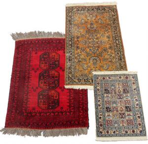Afghansk tæppe på rød bund samt to tæpper i Qum design. 20. årh. 144 x 105, 151 x 86 og 90 x 62. 3