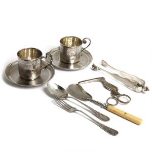 To franske kopper og underkopper, sukkertang, ske og gaffel af sølv. Vægt ca. 307 gr. Samt navlestrengssaks af sølvplet. 19.-20. årh. 7