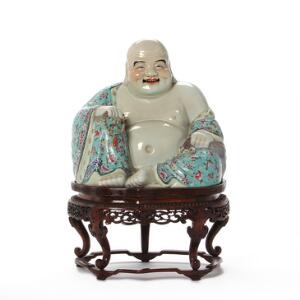 Kinesisk figur af porcelæn i form af Budai dekoreret i farver, bund med indpresset mærke. 20. årh. Tilhørende stand af hardwood. H. 2542 cm.