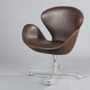 Arne Jacobsen Svanen. Hvilestol på drejestel monteret med hjul, betrukket med brunt skind. Udført hos Fritz Hansen.