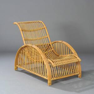 Arne Jacobsen Hvilestol med stel af flettet, formbøjet bambus, sider i form af gennembrudte halvcirkler. Model C.5208. Udført hos JV Holding.
