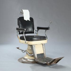 Vintage barberstol af cremefarvet jern, med drejefod, papirrulle i nakkestøtten samt regulérbar højde. Ca. 1950. H. 115.