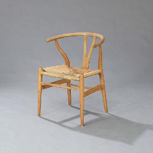 Hans J. Wegner Y-stolen. Armstol med stel af patineret eg. Sæde udspændt med flettet papirgarn. Model CH 24.