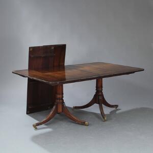 Engelsk two-pillar table af mahogni med tre tillægsplader, to profilerede søjler på trepas fodstykke. 20. årh. H. 76. L. 184. Hver plade L. 46. B. 115.