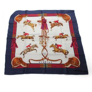 Hermés Kvadratisk silketørklæde med blå ramme og motiv af ryttere samt seletøj og sadler. Mannheim 1997. L. ca. 88 cm.