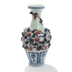 Kinesisk vase af porcelæn, dekoreret i blå med blomster og firben i relief. 20. årh. H. 30.