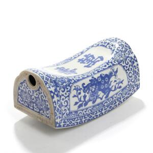 Orientalsk hovedpude af porcelæn, dekoreret i blå med transferprint i form af fo-hunde og skriftegn. 20. årh. L. 21.